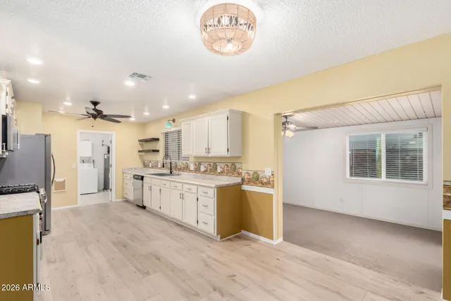 a large kitchen with kitchen island a sink stainless steel appliances and cabinets