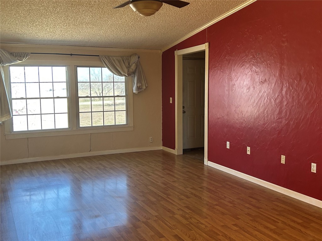 20406 Wilson Road, Unit B Coupland, TX 78615 - Photo 5 of 14 an empty room with wooden floor and windows