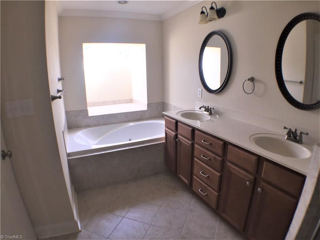 8275 Coldwater Road Stokesdale, NC 27357 - Photo 22 of 30 Master Bath showing dual vanities, jetted tub, and skylight