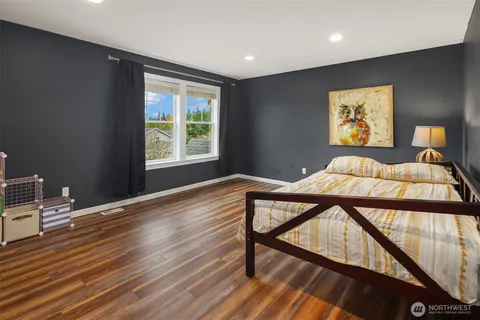 a bedroom with a bed and wooden floor
