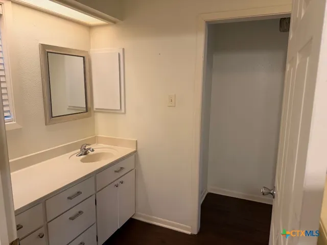 a bathroom with a granite countertop sink toilet and mirror