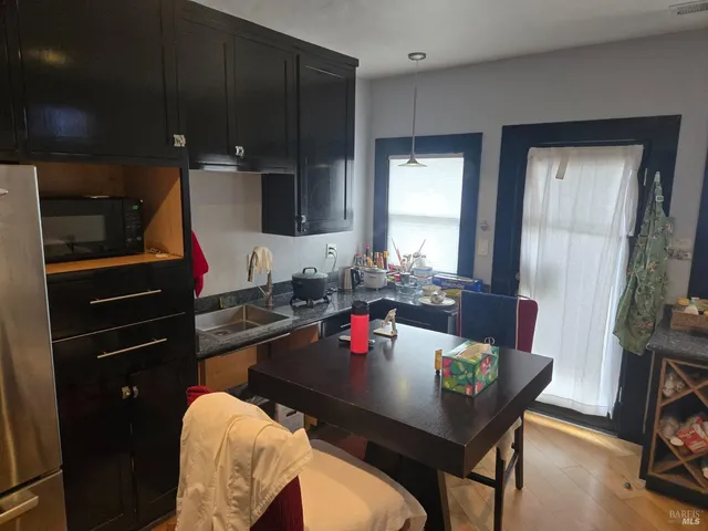 a living room with a couch and a dining table with wooden floor