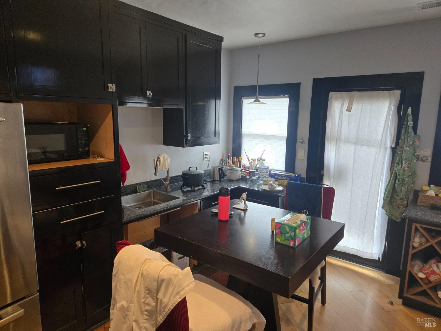 1510 4th Street Santa Rosa, CA 95404 - Photo 5 of 15 a living room with a couch and a dining table with wooden floor