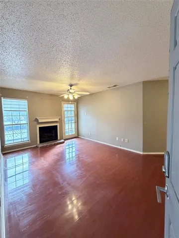 an empty room with windows and fireplace