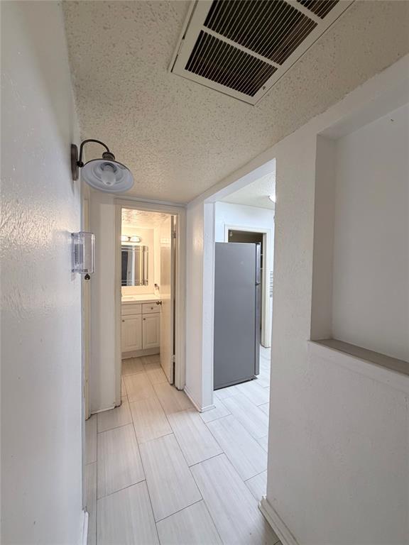18333 Roehampton Drive, Unit 622 Dallas, TX 75252 - Photo 12 of 28 a view of a hallway with a kitchen