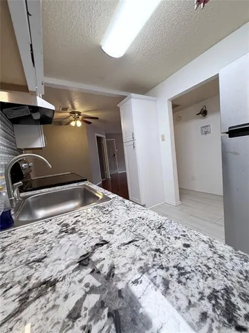 a view of a refrigerator in kitchen and white cabinets