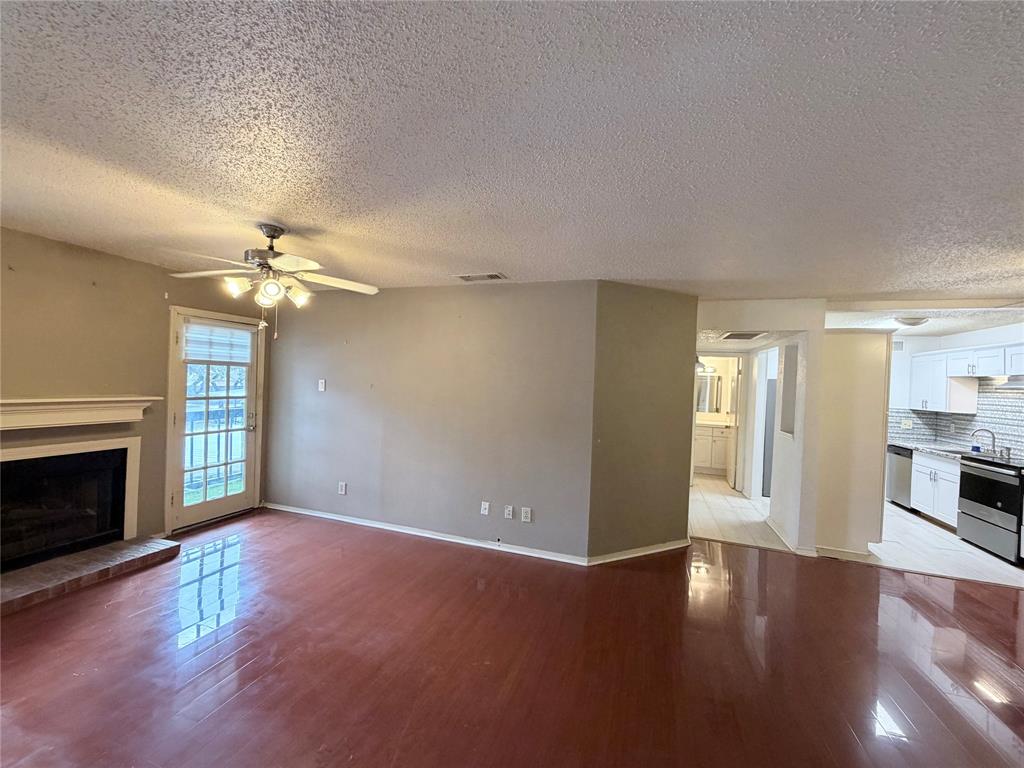 18333 Roehampton Drive, Unit 622 Dallas, TX 75252 - Photo 3 of 28 a view of a livingroom with a ceiling fan fireplace and wooden floor
