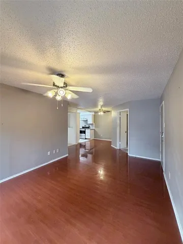 a view of a livingroom with a ceiling fan and wooden floor