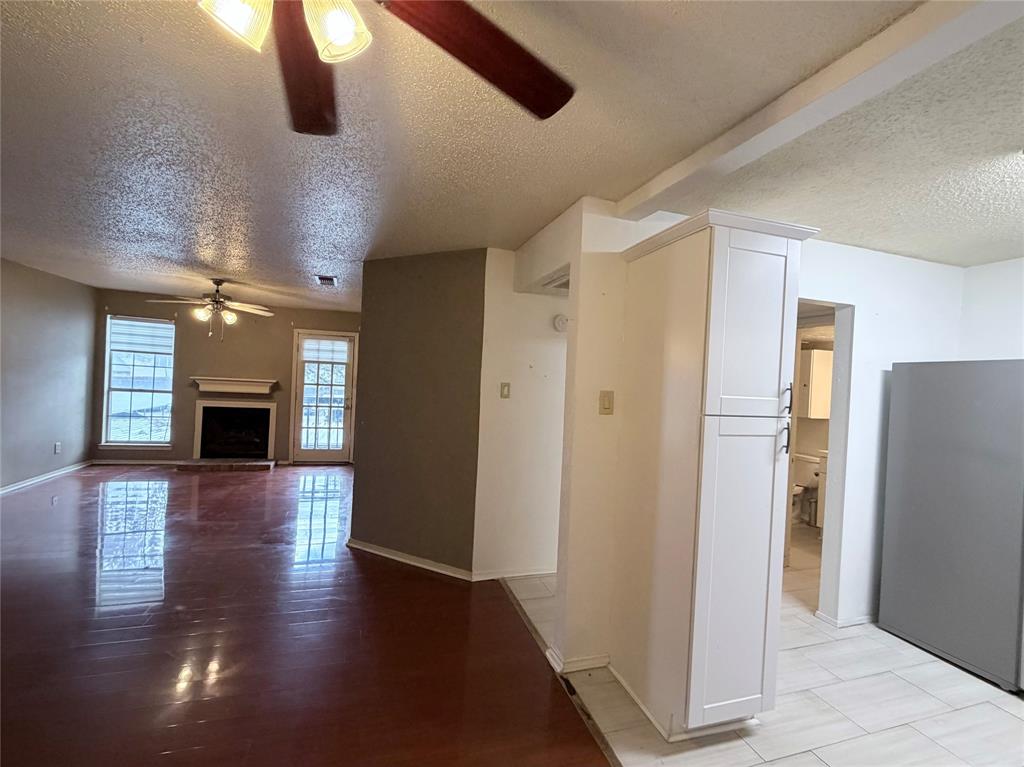 18333 Roehampton Drive, Unit 622 Dallas, TX 75252 - Photo 6 of 28 a view of a hallway with wooden floor and a kitchen