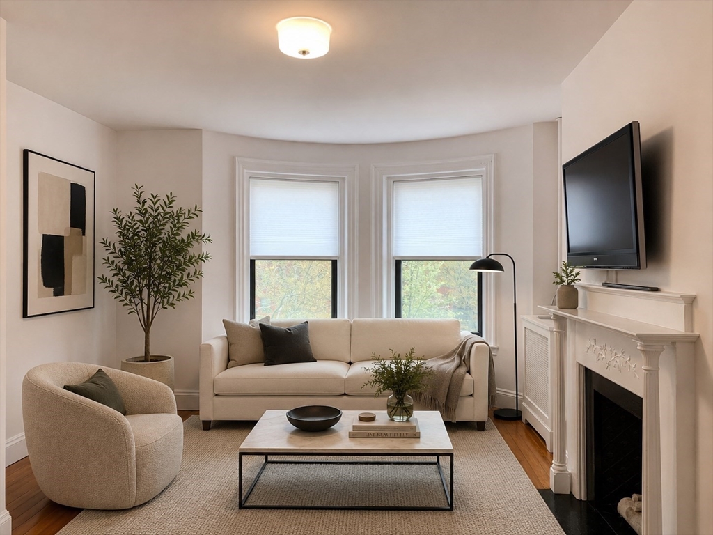 1064 Beacon Street, Unit 9 Brookline, MA 02446 - Photo 3 of 19 a living room with furniture a flat screen tv and a fireplace