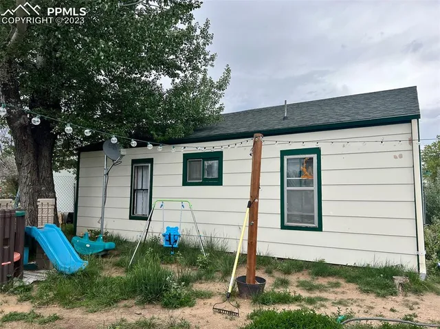 an empty room with a window and a ceiling fan