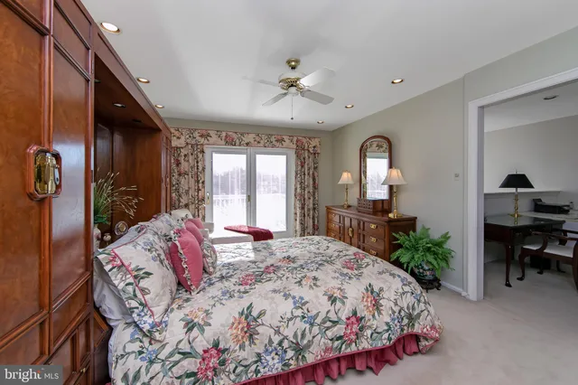a spacious bedroom with a large bed a chandelier and windows