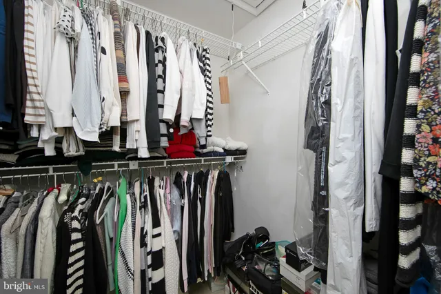 a view of walk in closet with clothes