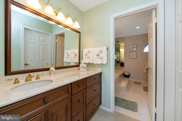 a spacious bathroom with a granite countertop sink mirror and shower