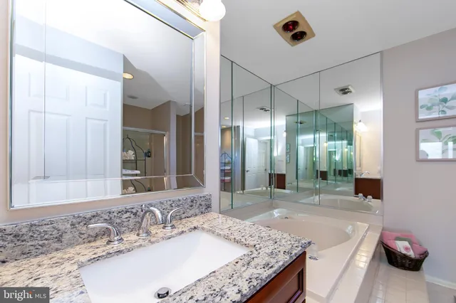 a bathroom with a granite countertop sink and a mirror