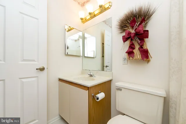 a bathroom with a toilet sink vanity and mirror