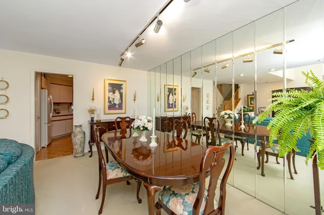 a view of a dining room and livingroom with furniture wooden floor a rug a potted plant and a chandelier
