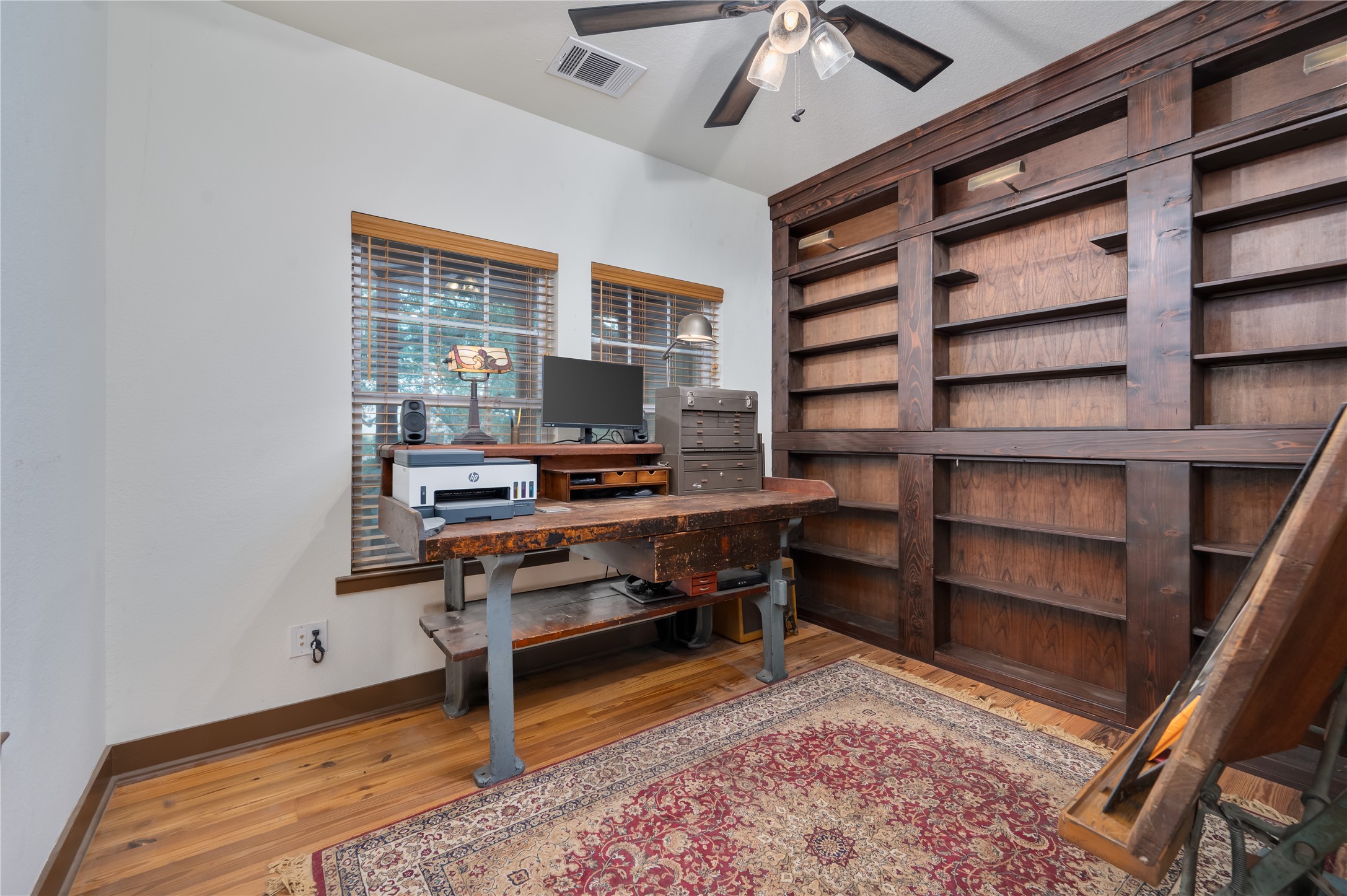 270 Dry Creek Road Manor, TX 78653 - Photo 15 of 40 Well-lit study with built-in wooden bookshelves and rich hardwood flooring.