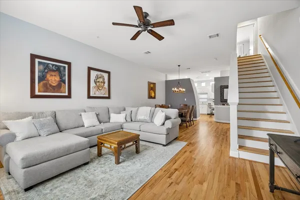 a living room with furniture and a wooden floor