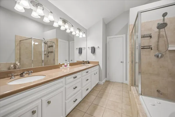 a spacious bathroom with a double vanity sink mirror and shower