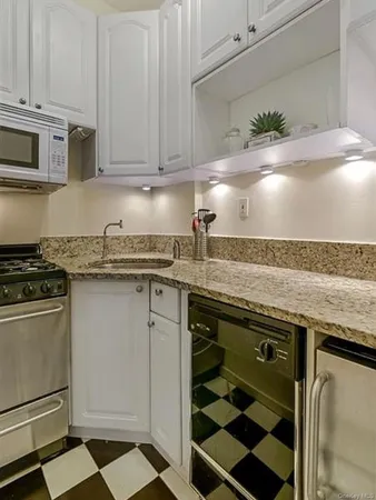 a kitchen with stainless steel appliances granite countertop a sink stove and cabinets