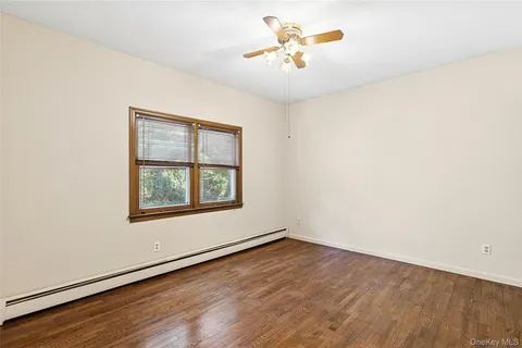 an empty room with a window and wooden floor