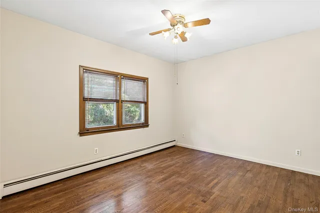an empty room with a window and wooden floor