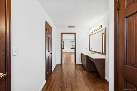 a hallway with white cabinets and wooden floor