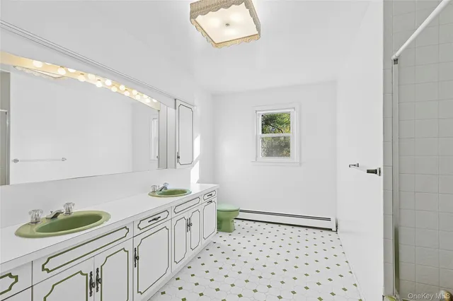 a bathroom with a sink a toilet a mirror and shower