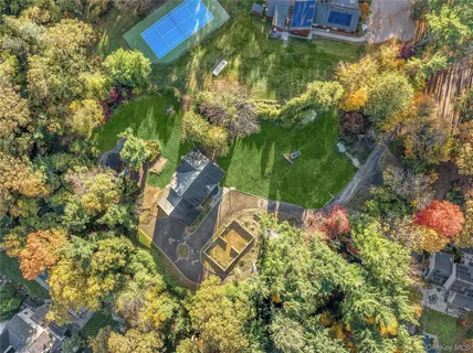 an aerial view of residential houses with outdoor space and trees