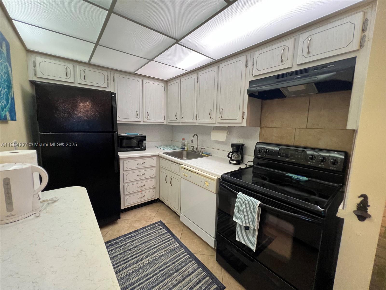 108 Bravado Lane, Unit 8 Palm Beach Shores, FL 33404 - Photo 2 of 17 a kitchen with a stove and a microwave