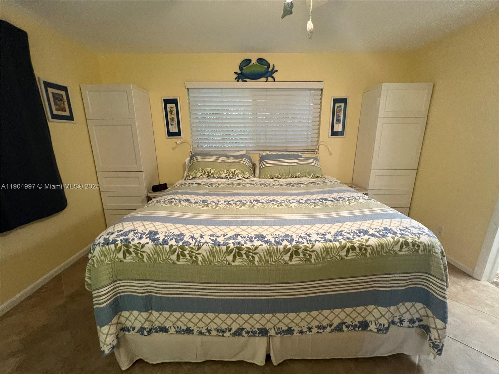 108 Bravado Lane, Unit 8 Palm Beach Shores, FL 33404 - Photo 10 of 17 a bed sitting in a bedroom next to a window