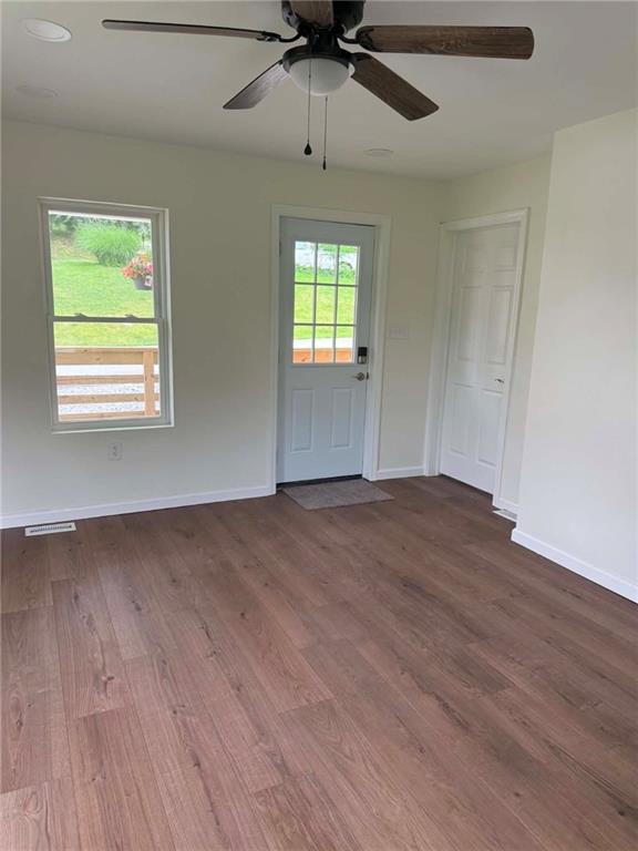 89 Old 51 Road Perryopolis, PA 15473 - Photo 10 of 45 an empty room with wooden floor chandelier fan and windows