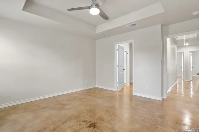an empty room with fan and entrance