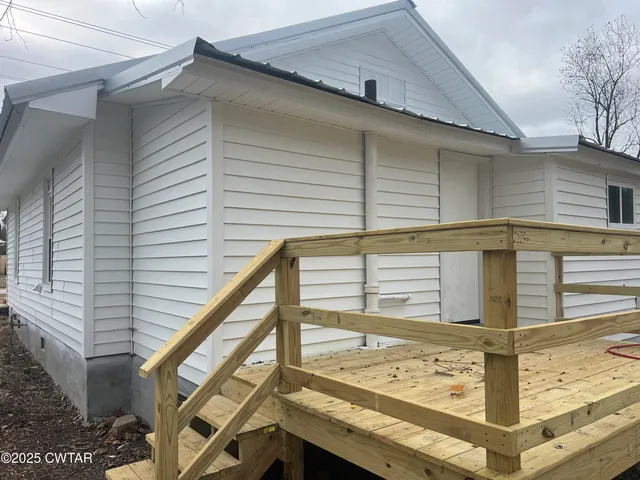 a view of a balcony with wooden floor and fence