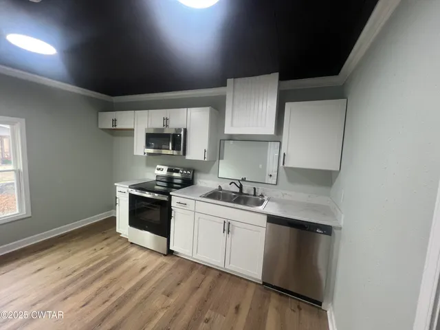 a kitchen with a sink stove top oven and cabinets