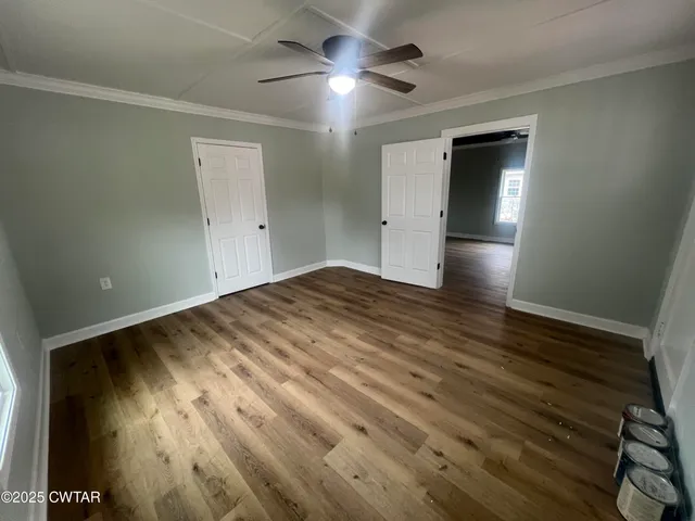a view of empty room with wooden floor