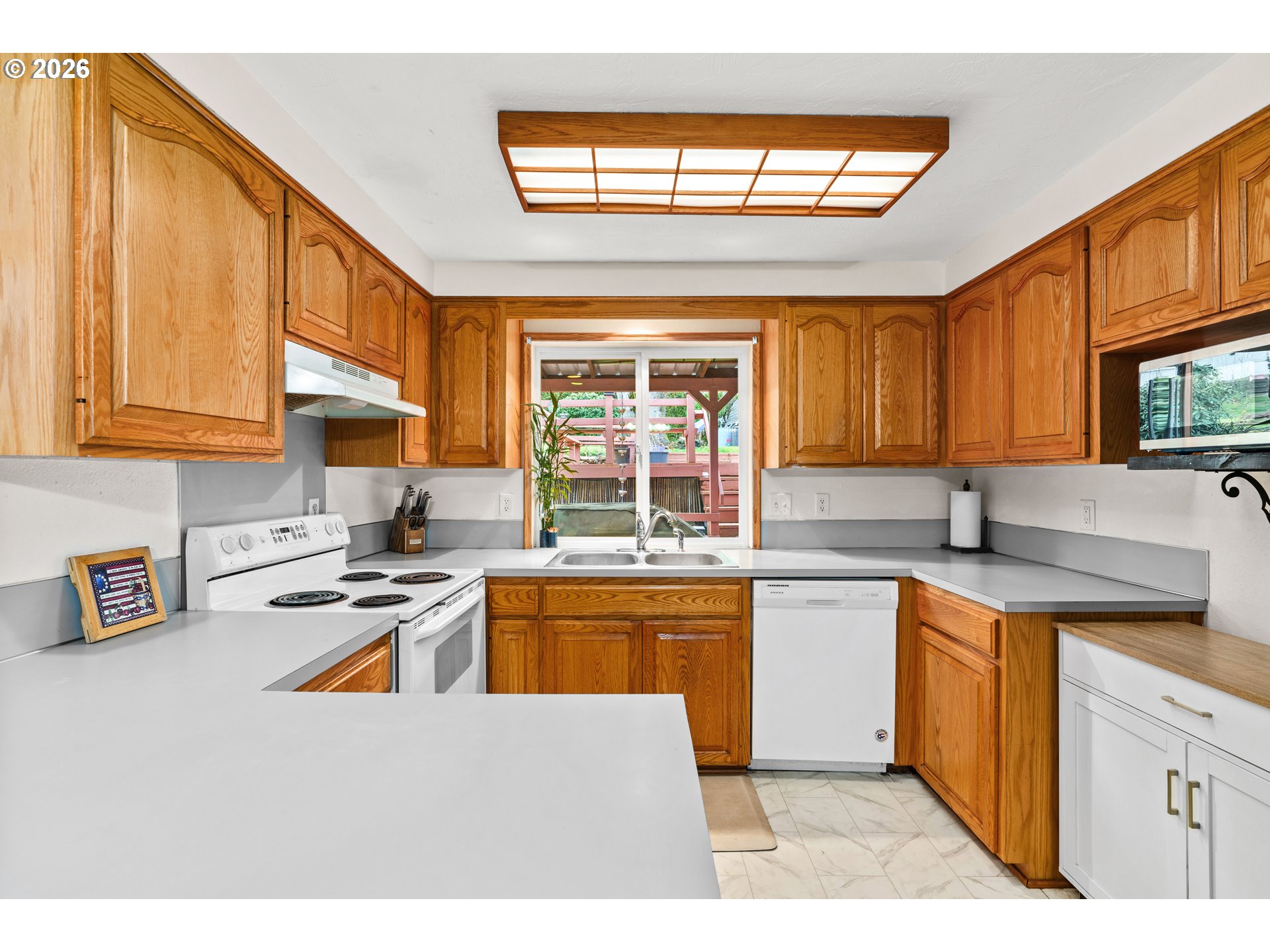 7027 South E Street Springfield, OR 97478 - Photo 13 of 39 a kitchen with stainless steel appliances granite countertop a sink a stove a counter space and a window