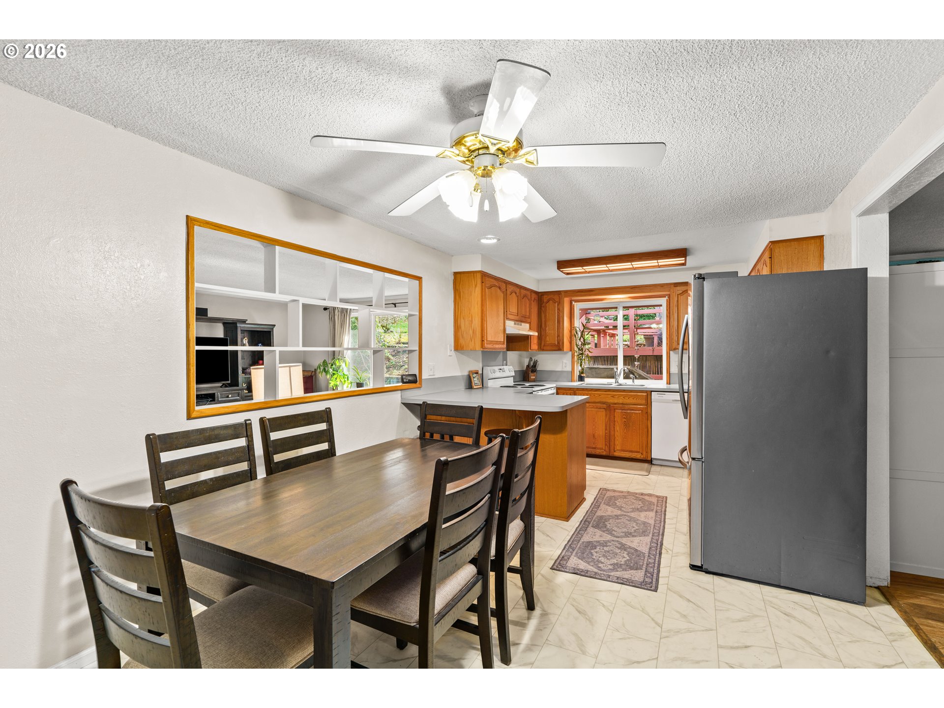 7027 South E Street Springfield, OR 97478 - Photo 10 of 39 a dining room with furniture a chandelier a large window and stainless steel appliances
