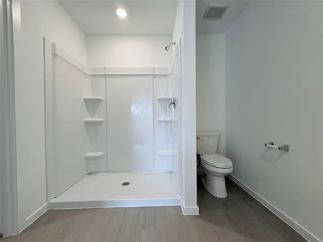 a bathroom with a shower a toilet and a shower