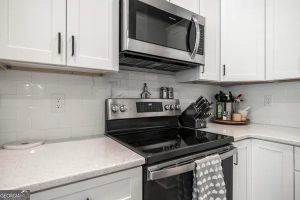 a kitchen with stainless steel appliances a refrigerator sink and white cabinets