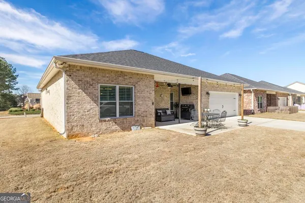 a view of a house with backyard and a tree