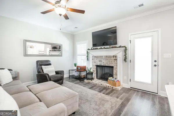 a living room with furniture a flat screen tv and a window