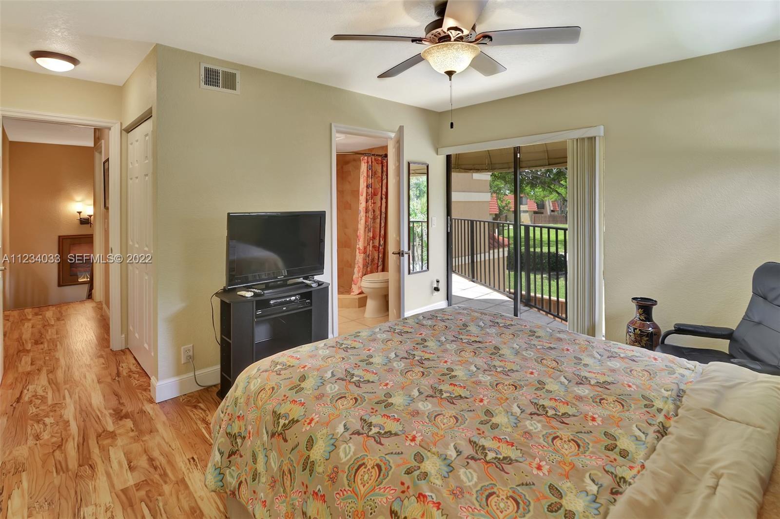8171 Thames Boulevard, Unit A Boca Raton, FL 33433 - Photo 28 of 34 a bedroom with a bed and a flat screen tv