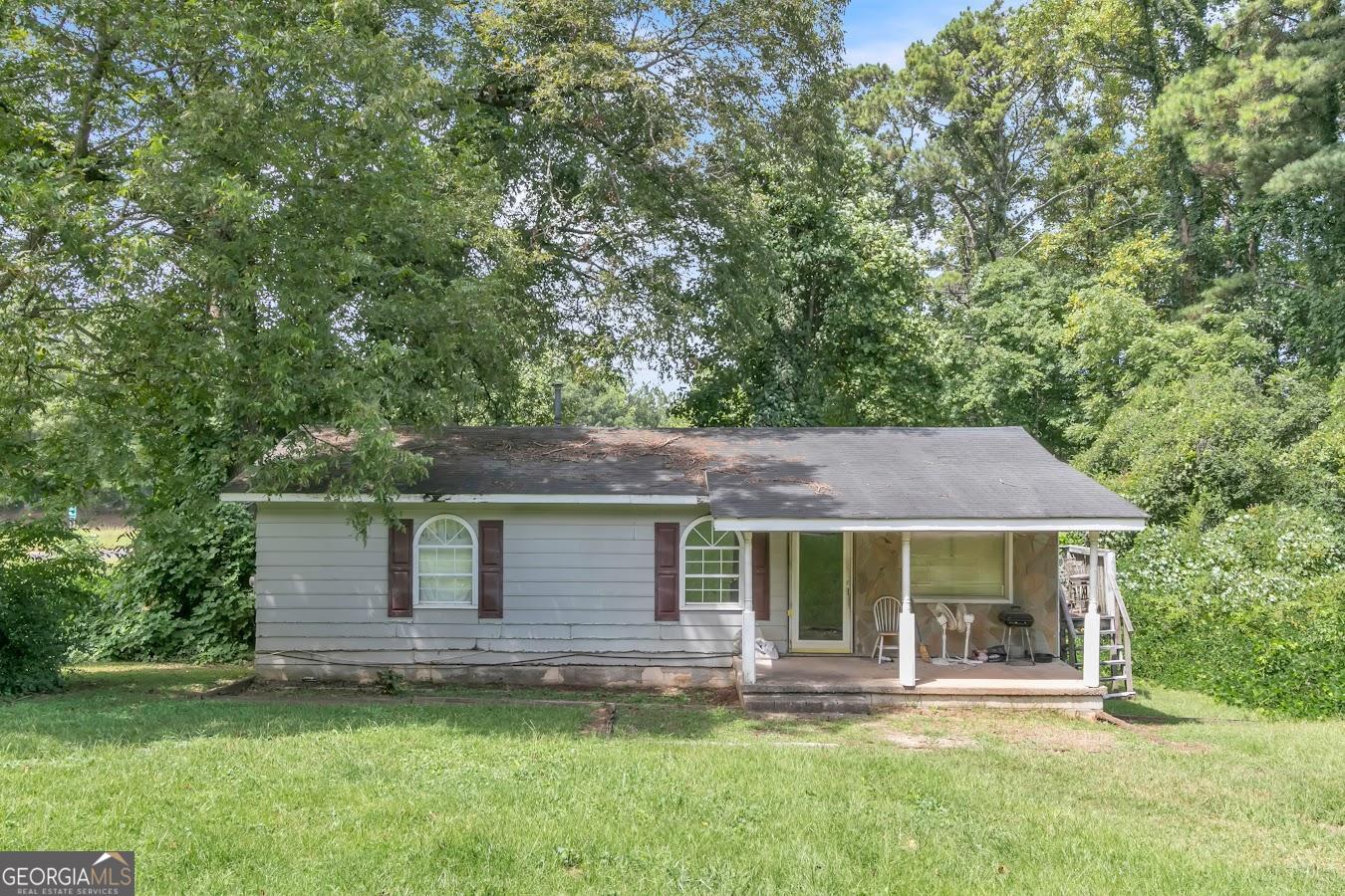 a view of a house with a yard and sitting area
