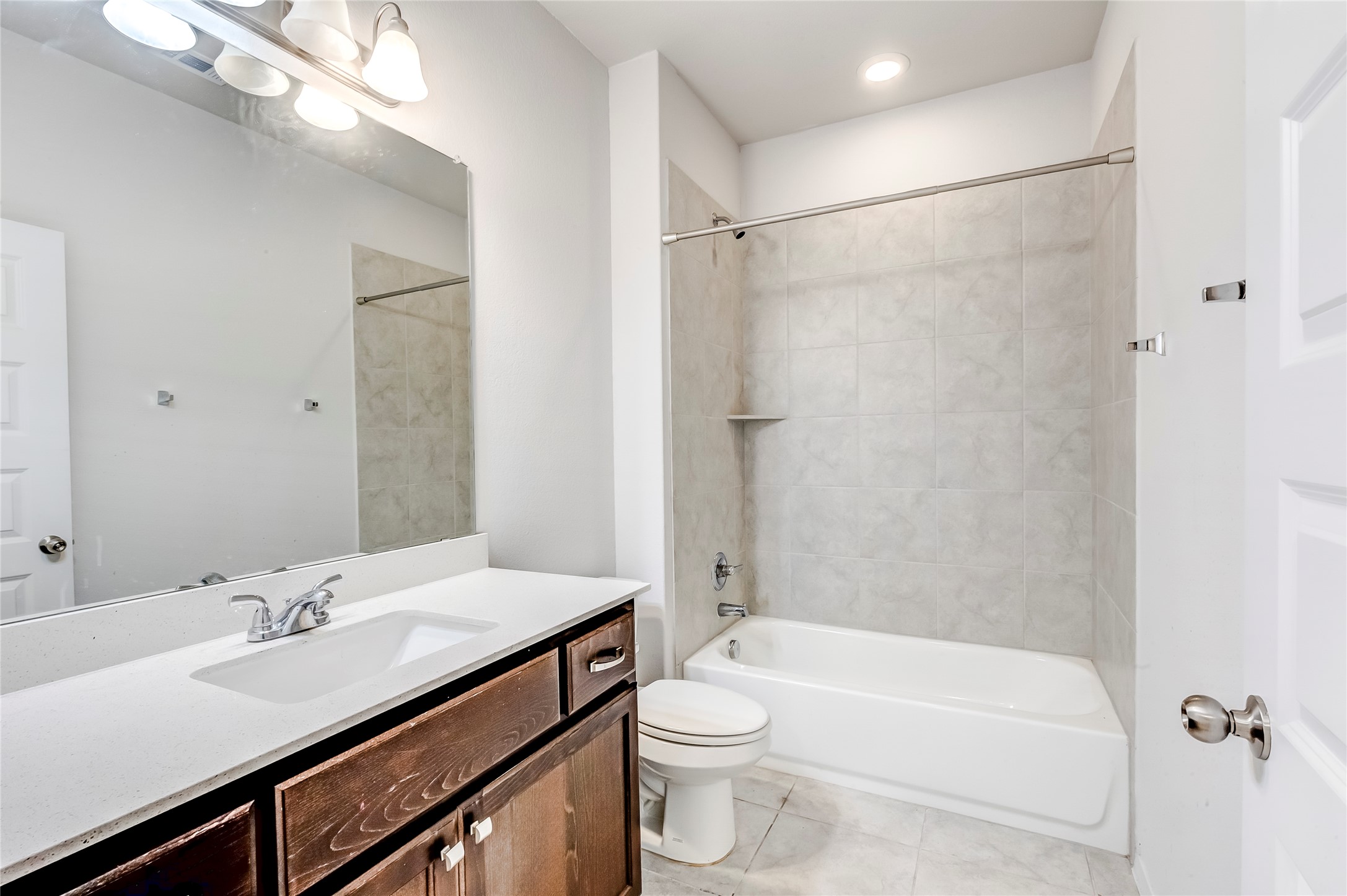 2721 Winding Creek Road Kyle, TX 78640 - Photo 22 of 27 Bathroom featuring a built-in tub and shower combination with light-toned wall tiling