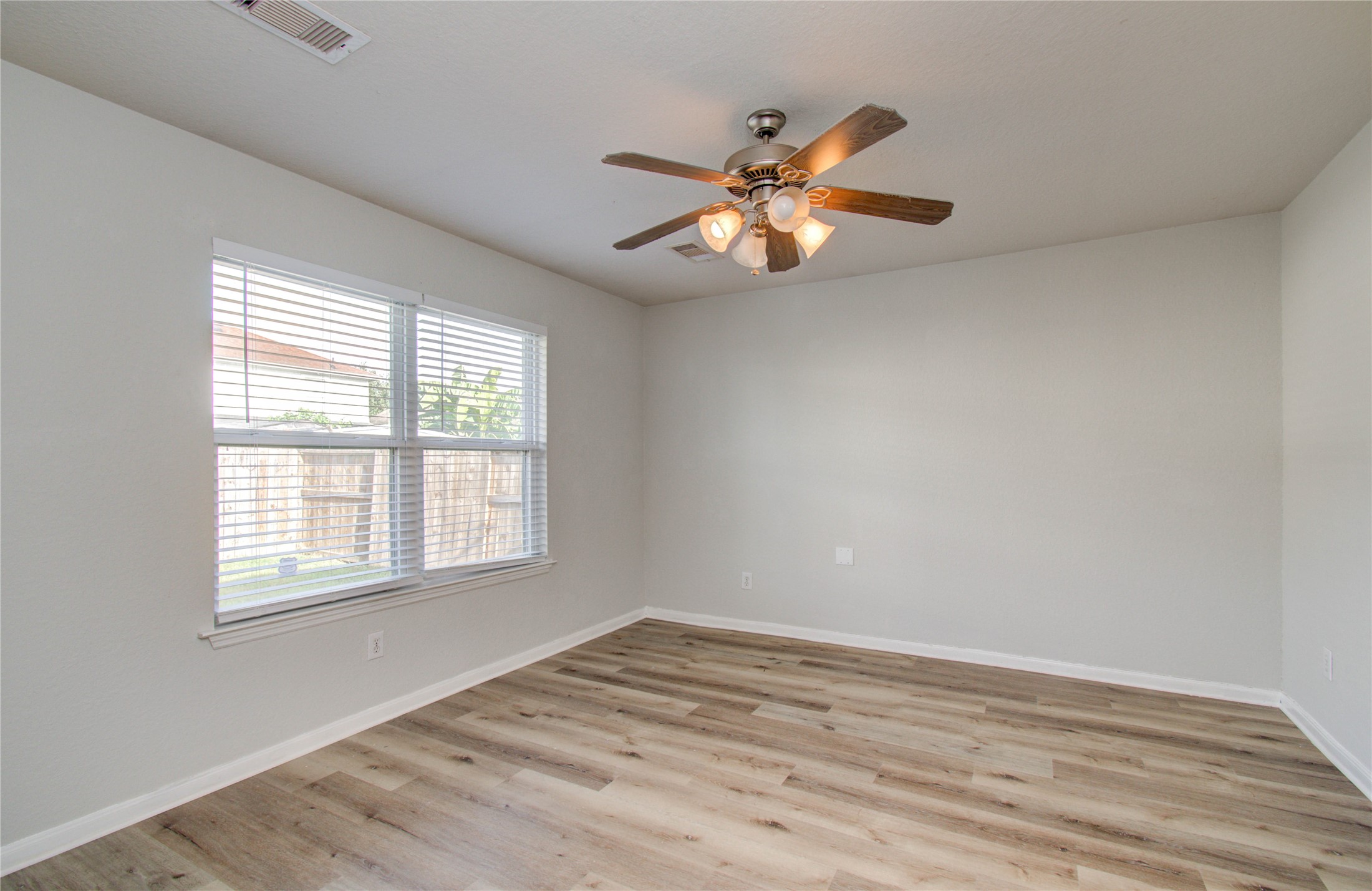 13231 Ridgewood Knoll Lane Houston, TX 77047 - Photo 13 of 23 a view of an empty room with wooden floor and a window