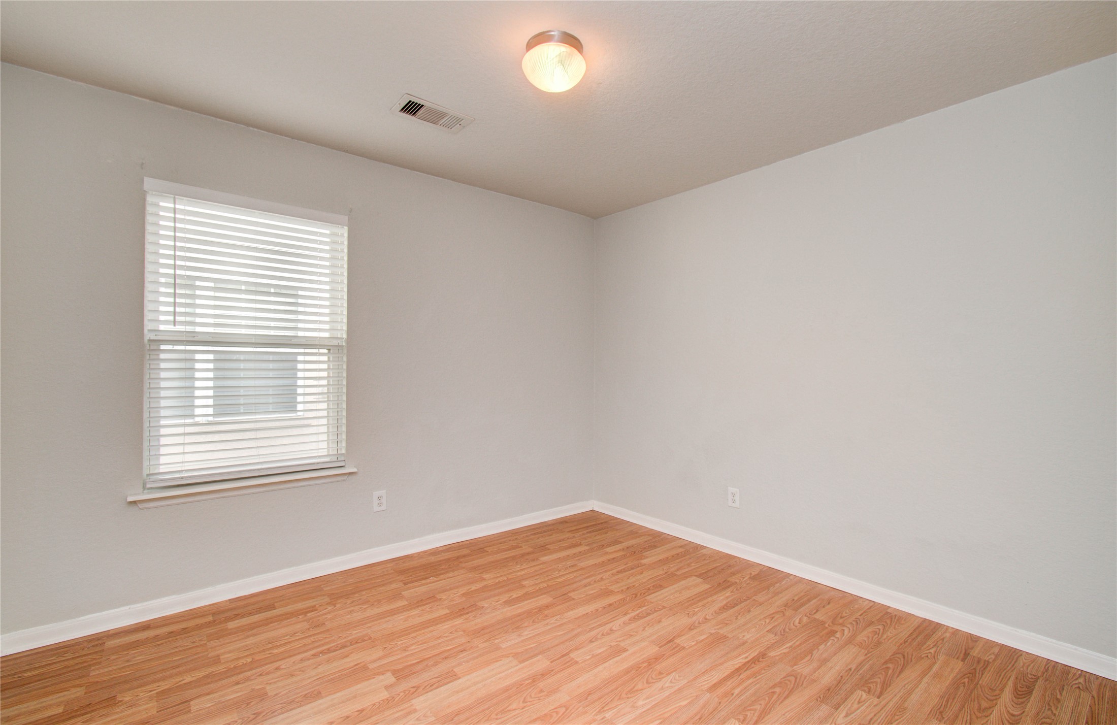 13231 Ridgewood Knoll Lane Houston, TX 77047 - Photo 17 of 23 a view of an empty room with wooden floor and a window