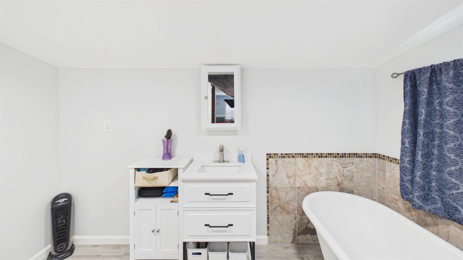 735 Ridge Road Mokelumne Hill, CA 95245 - Photo 10 of 24 Bathroom featuring white freestanding bathtub with natural stone-look tile surround and mosaic accent