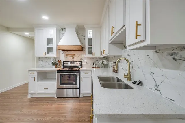 a kitchen with granite countertop a sink stainless steel appliances and cabinets